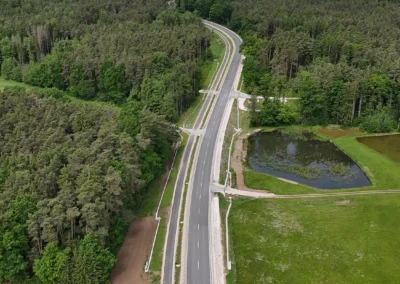 Eine zweispurige Straße in der Nähe von Freystadt, gesäumt von Wald und Feldern.