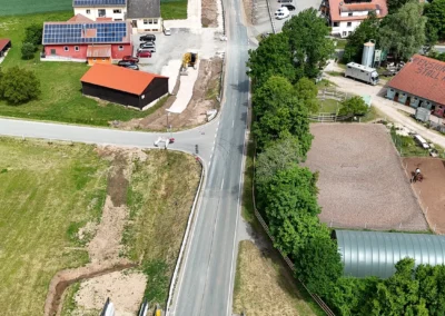 Luftaufnahme von Landstraße, Häusern, Ackerland und Brücke bei Freystadt.