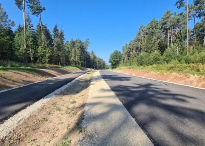Die frisch geteerte Straße in Reckenstetten führt durch den Wald unter freiem Himmel.
