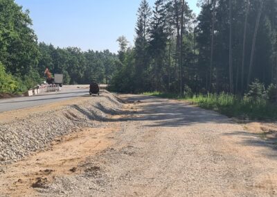 Straßenbau mit Schotter, Sand, Maschinen bei Freystadt; Bäume, sonniger Tag.