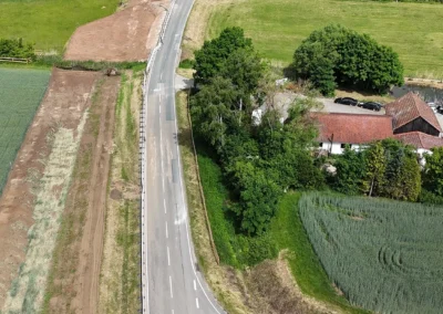 Luftaufnahme: Eine asphaltierte Straße schlängelt sich durch Freystadts Felder, Häuser und Bäume.